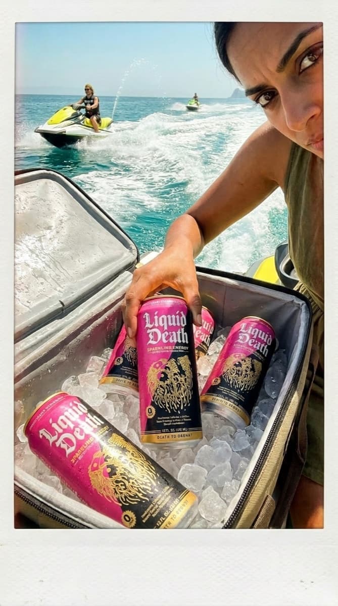 Real Vermeer render: cans on ice in a boat cooler, jet skis behind, shot like a phone polaroid